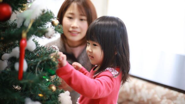 Child putting decorations on Christmas tree