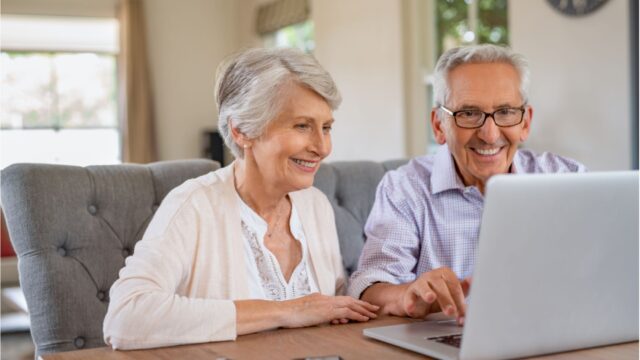 Senior couple looking at a will on a laptop