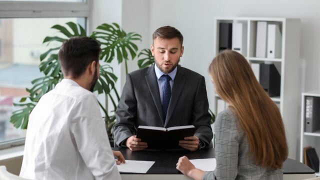 Unhappy young couple visiting divorce lawyer in an office